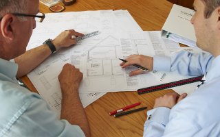 Two men looking at building design plans. Local authority building control (LABC) 